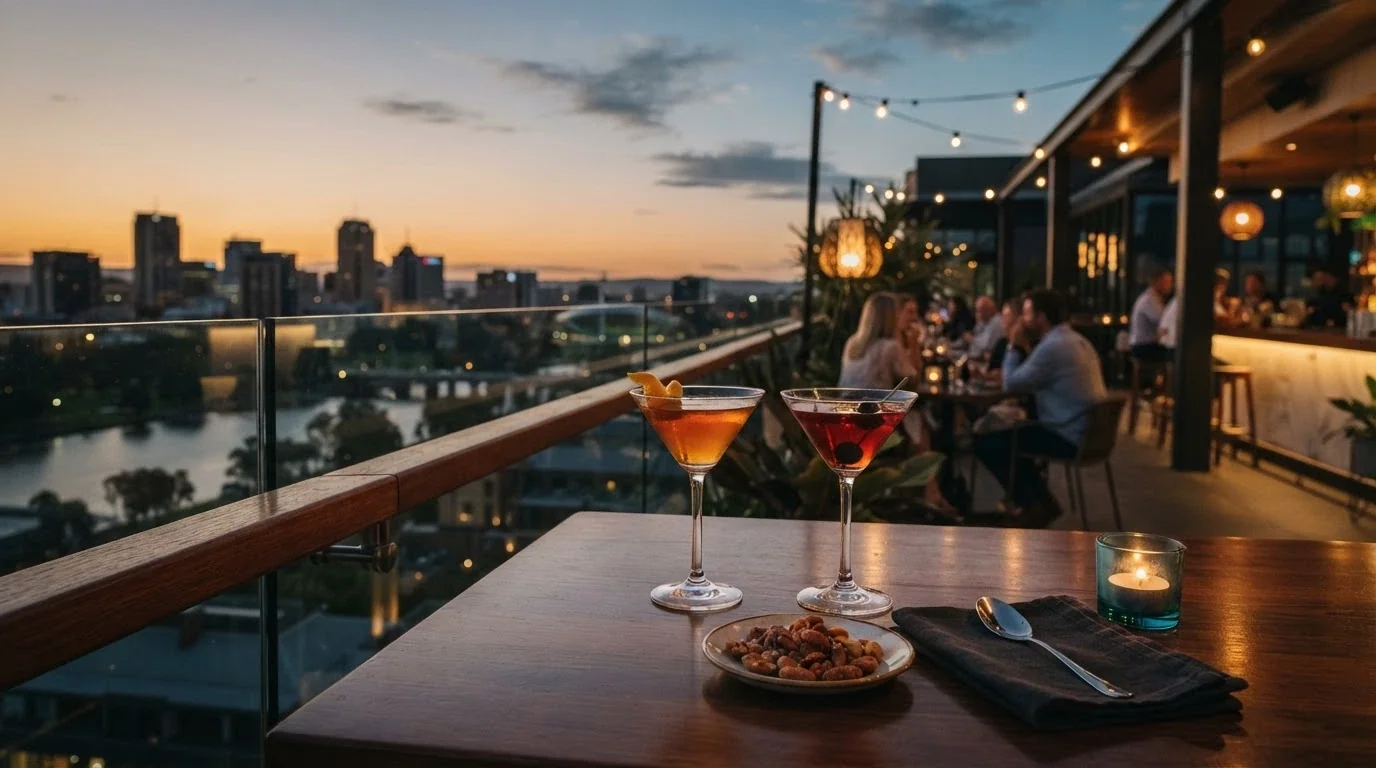 The SOL Rooftop on level nine at dusk, with cocktail glasses on a table, the city skyline in the background, and ambient bar lighting